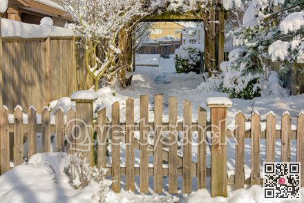 Wooden fence and gate of residential area entrance on bright winter day