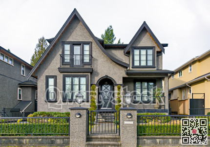 Gloomy residential house with metal fence in front on overcast sky background
