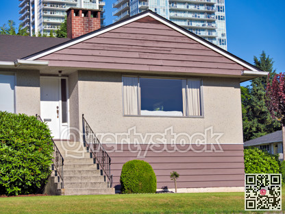 Green lawn and main entrance of average residential building in British Columbia, Canada