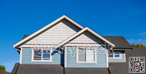 Top storey of residential house on blue sky background