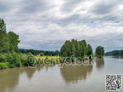 A picturesque riverside scene with a white church on the shore.