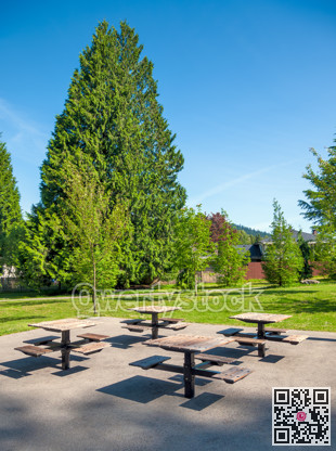 Small park with four tables and benches in a residential area