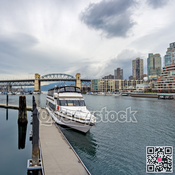 Tourist tour boat moored at the pier with Burrard bridge and Vancouver downtown on the background