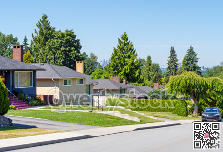 Street of residential houses with a car parked on side. Residential area with Metrotown view