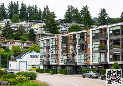 A perfect neighborhood. Uphill residential area with cars parked on the streets around the building
