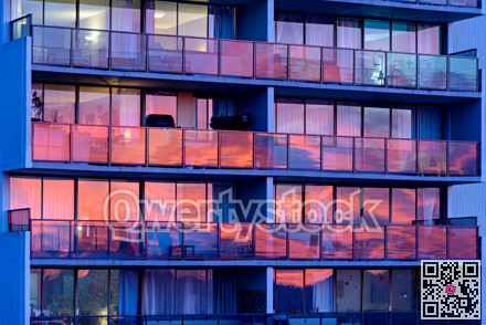 Colorful reflections of sunset in windows of residential building in Vancouver