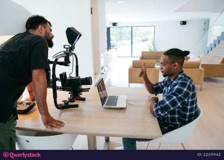 A cameraman talking with an African American man as they preparing to shoot a commercial video. High quality photo photo 2209942